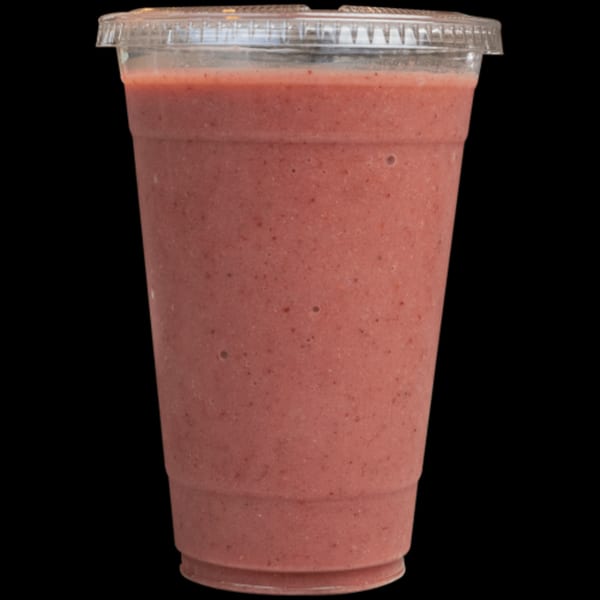 A Green Table Cafe strawberry smoothie in a clear plastic cup with a lid.
