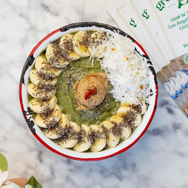Overhead view of a Green Table Cafe smoothie bowl with bananas, chia seeds, coconut, and nut butter.