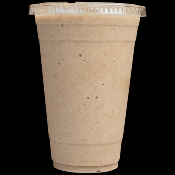 A light brown smoothie with dark flecks in a clear plastic cup with a lid.