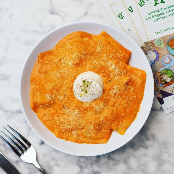 Green Table Cafe's ravioli in orange sauce with a dollop of cream and microgreens.