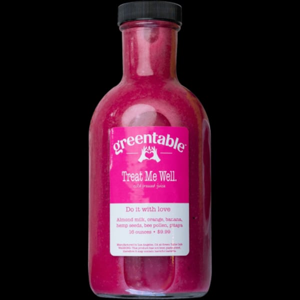 A bottle of Green Table Cafe's "Treat Me Well" cold-pressed juice, a vibrant pink blend.